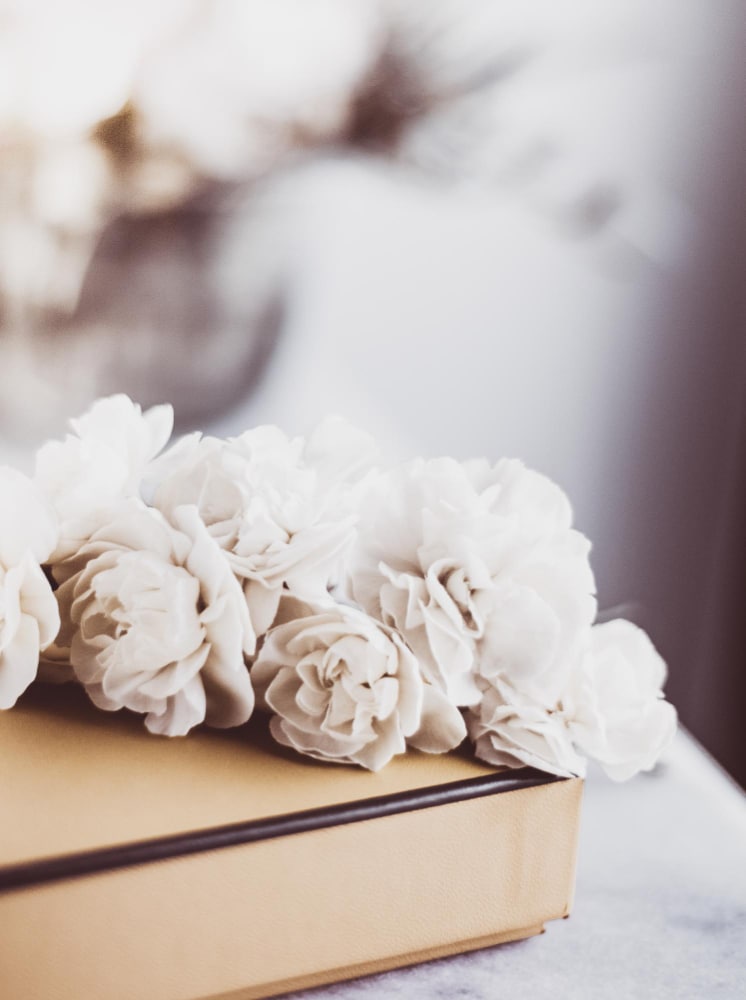Weiße Blumen auf einem Buch – stilles Symbol für Abschied und Trauer
